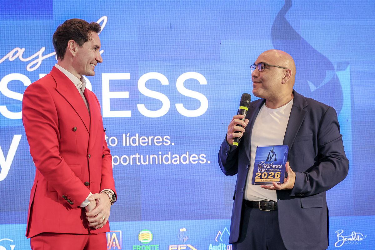 João Adolfo e João Alves no palco diante do telão do Brasil Business Day