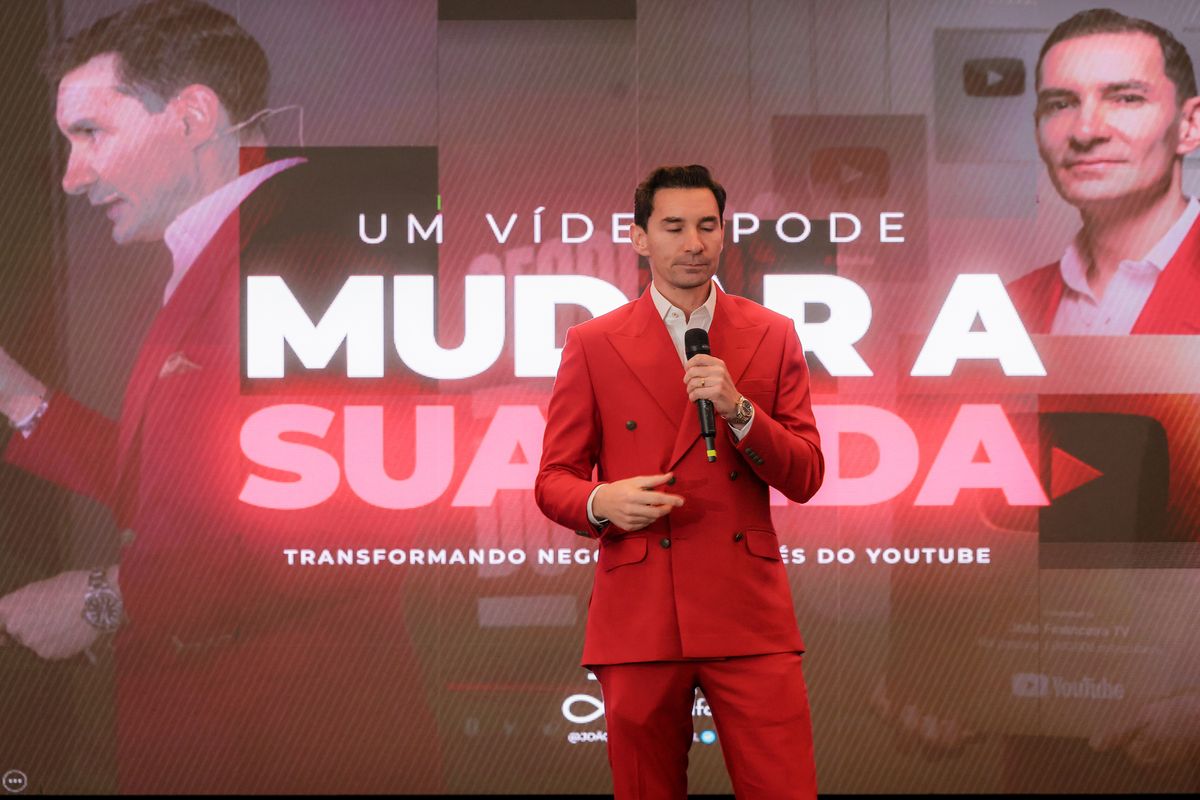 João Adolfo durante sua palestra, diante do telão