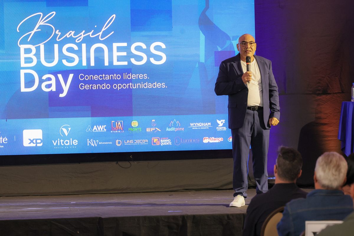 João Alves no palco diante do telão do Brasil Business Day